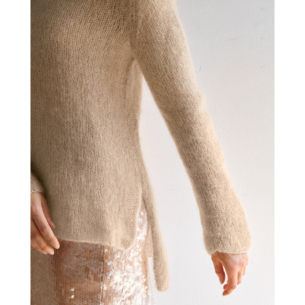 Vrouw in een lichte trui en glanzende broek tijdens een stijlvolle modeshoot - Lana Grossa Filo Di Gio Bordeaux, sfeerfoto 5 - Lana Grossa Filo Di Gio 001 Crème