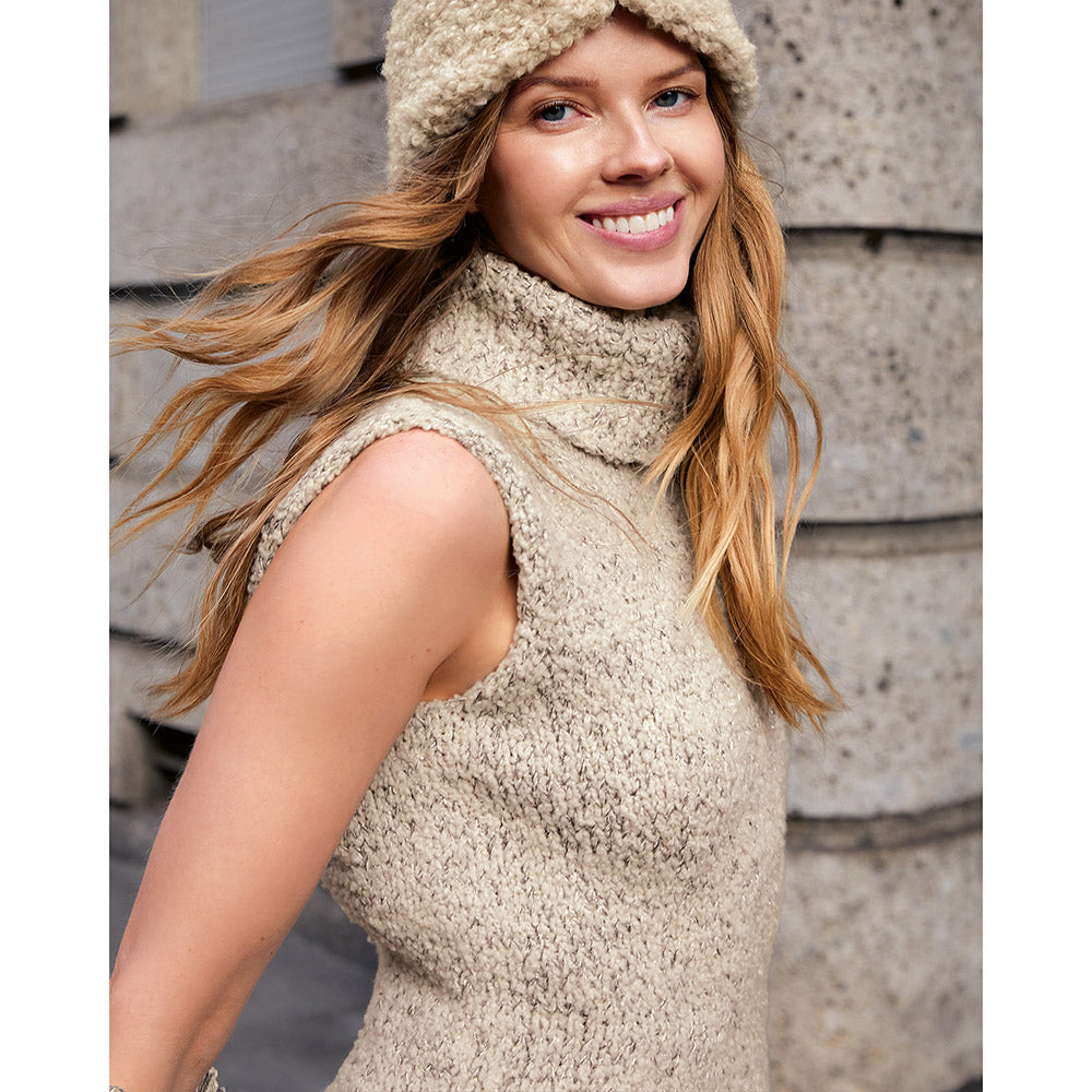 Model draagt een beige gebreid schoudervest met striksluiting - Lana Grossa Orsettini 002 Roodviolet