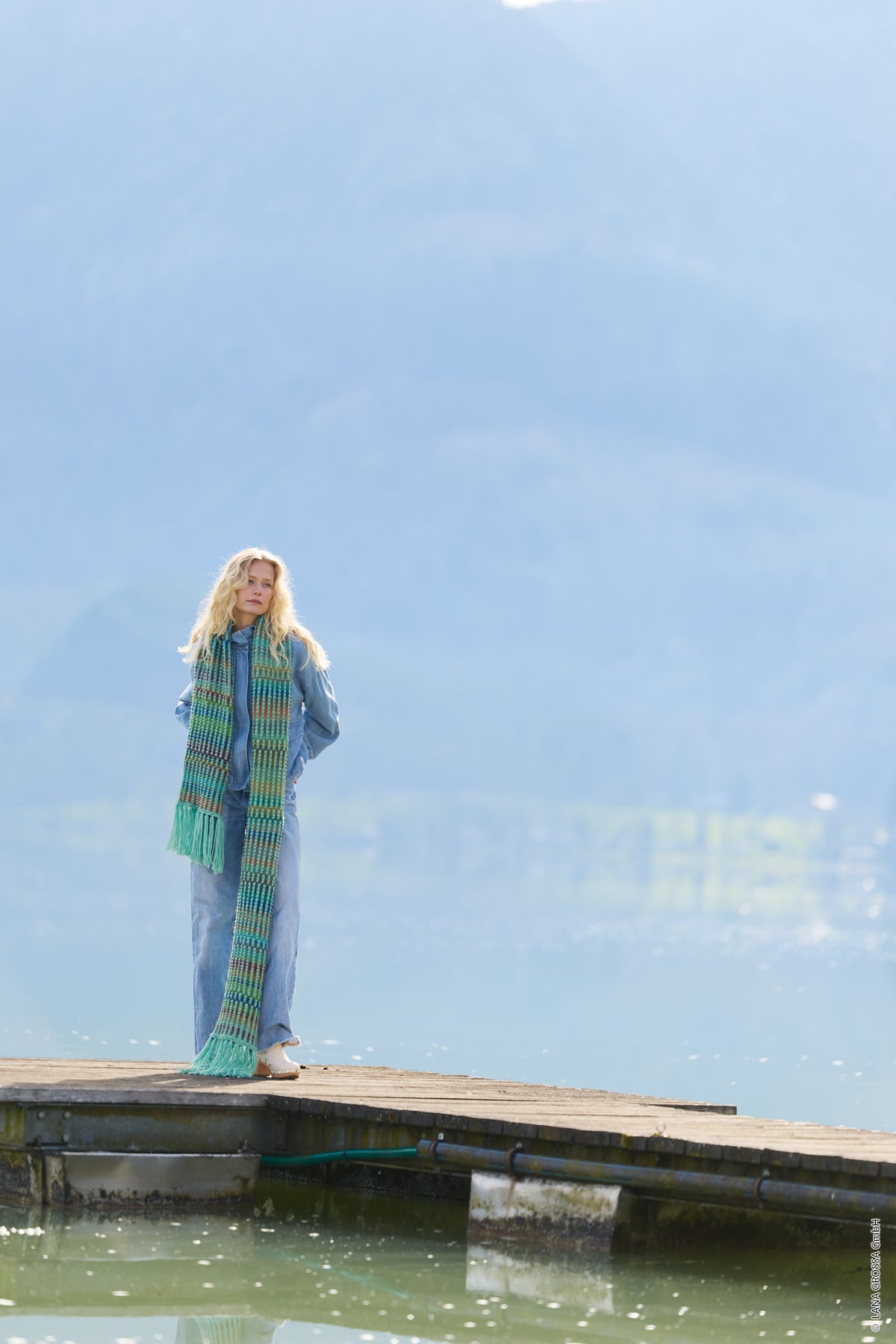 Lana Grossa Doeken & Co Nr. 10 model 1 - vrouw op een steiger met lange turquoise sjaal - Farfalla en Cool Merino