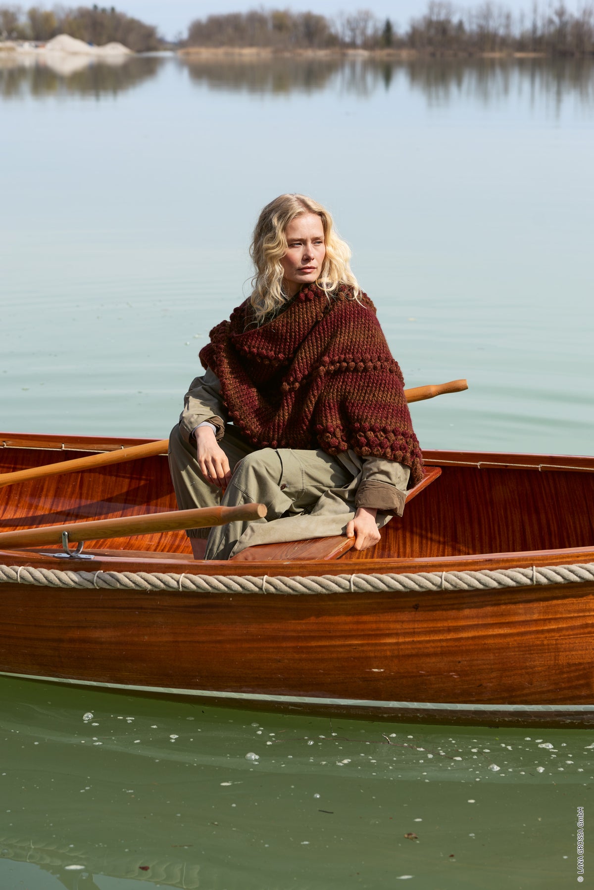 Lana Grossa Doeken & Co Nr. 10 model 7 - vrouw in een boot met donkerrode omslagdoek - Ecopuno Sfumato