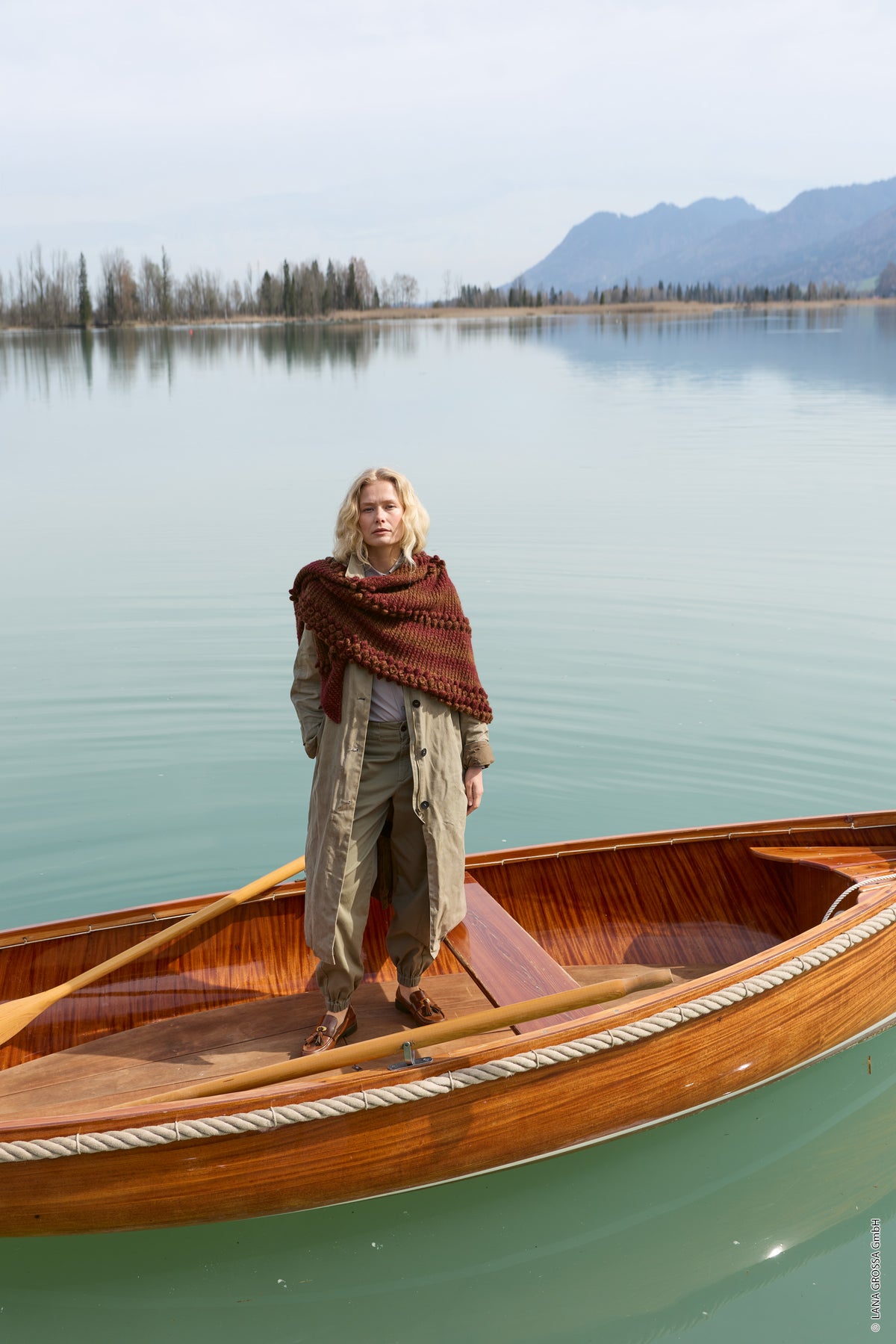 Lana Grossa Doeken & Co Nr. 10 model 7 - vrouw staand in boot met donkerrode omslagdoek - Ecopuno Sfumato
