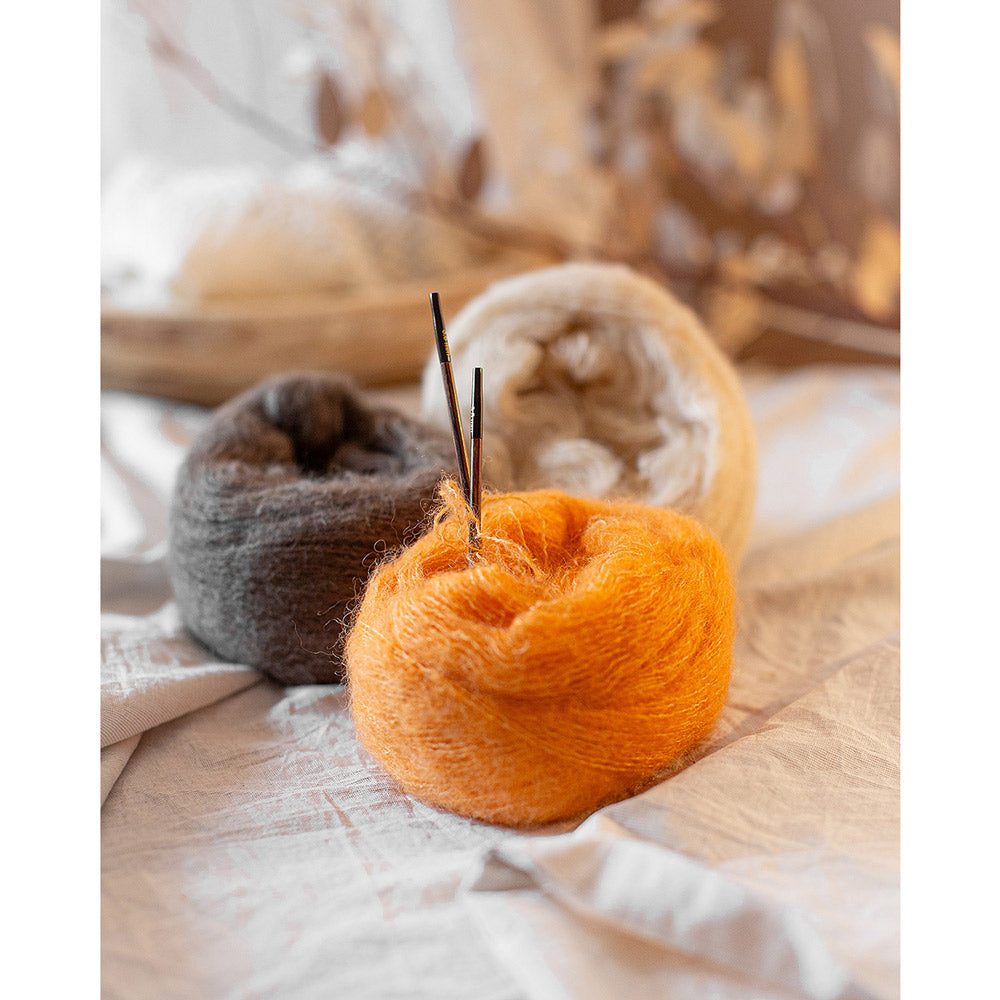 Lana Grossa Setasuri 062 Umbra - sfeerfoto met een oranje bol Lana Grossa Setasuri en breiwerk op tafel - sfeerfoto 30